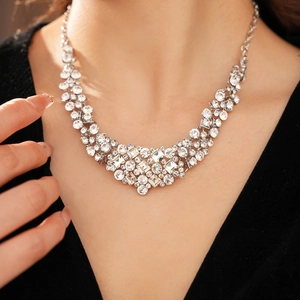 Close-up of geometric diamond-set necklace worn on neck in refined palace style