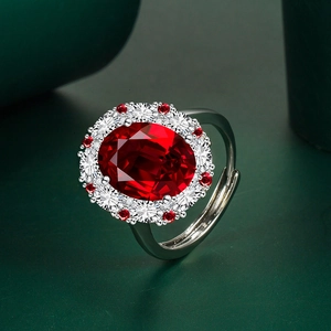 Close-up of luxury oval red ruby ring with sparkling white diamond cluster setting