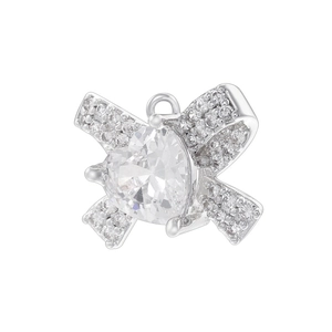 Close-up of a silver bow pendant with a heart-shaped crystal and pavé detail
