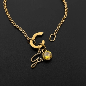 Gouden titanium stalen ketting met letter C, G bedels en gele zirkoon