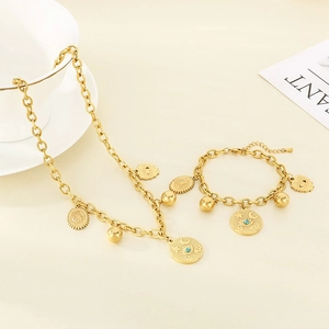 Close-up of gold chunky chain necklace and bracelet with sun moon and eye pendants