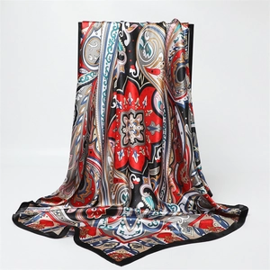Macro shot of paisley and floral pattern details on black satin silk square scarf