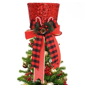 Detail of red sequin Christmas tree topper hat with buffalo plaid bow and pine cone decor