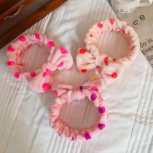 Three-pack plush polka dot bow headbands in shades of pink for face washing and skincare