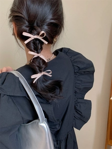 Detailopname van drie roze lintstrikken gestyled op een vlecht voor een lieve look
