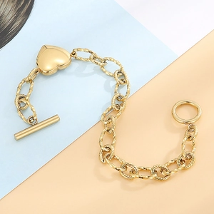 Bracelet doré avec pendentif cœur chaîne en spirale et fermoir OT sur fond moderne