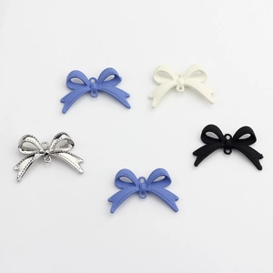 Detail of colorful alloy bow pendants with center holes for DIY jewelry making