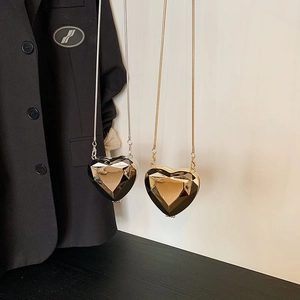 Mini heart-shaped crossbody chain bags in glossy black and gold with diamond-cut texture