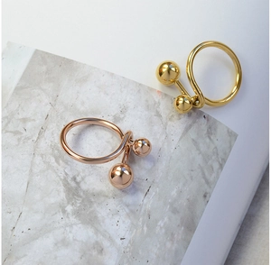Detailed macro view of 18K gold and rose gold plated titanium steel double ball open rings