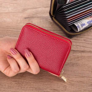 Detailed close-up of a red litchi grain leather card holder with secure gold zipper