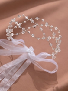 Close-up of handmade vintage bridal crystal headband with mesh beading and white ribbon