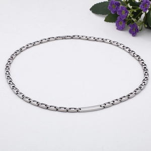 Detail of silver titanium steel chain necklace with minimalist curved bar pendant