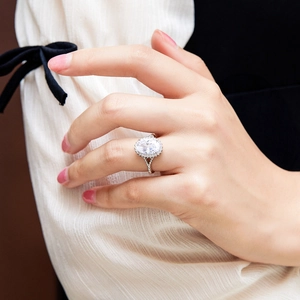 Macro shot of oval cut zircon halo ring with split shank on female hand