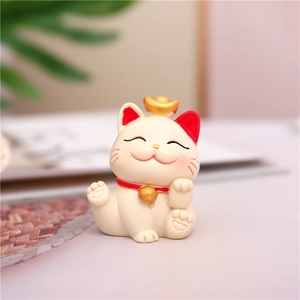 Close-up of a cute beckoning cat figurine with a golden ingot and bell detail