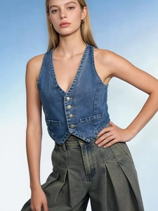 Detailed view of vintage blue denim vest fabric with retro metal buttons and washed texture