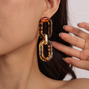 Detail view of retro acrylic leopard print earrings on a model for a vintage look