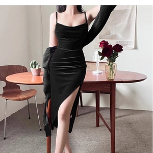 Close-up of elegant black velvet dress featuring a side slit and refined gathered details