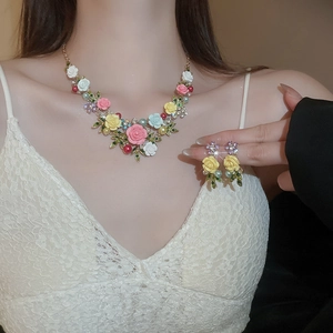 Detail shot of the 3D rose flower necklace and matching earrings set with pearls