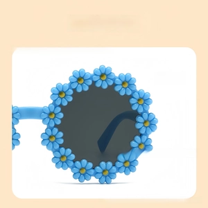 Detailed shot of sunflower petal frame and grey lenses on blue kids sunglasses
