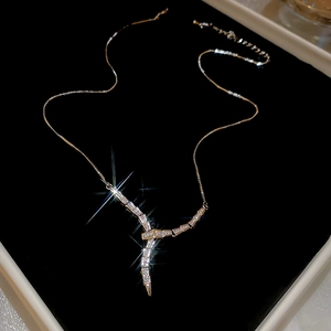 Sparkling gold serpent necklace with pavé cubic zirconia on premium black velvet