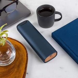 Navy blue aluminum 7-day pill organizer box with stylish wooden lids on marble surface