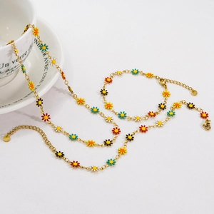 Colorful enamel daisy necklace and bracelet set in gold finish on white background