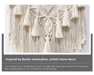 Detail of bohemian macrame wall hanging featuring hand-woven geometric patterns and cotton fringe