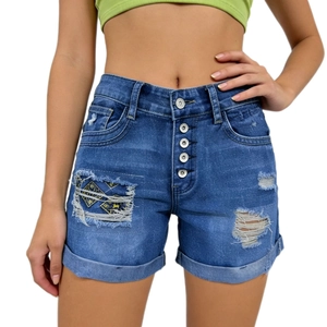 Detailed close-up of dark blue denim shorts with metal buttons and geometric embroidery