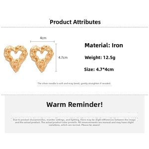 Detailed view of large gold crinkled heart earrings with size 4.7x4cm and silver pins