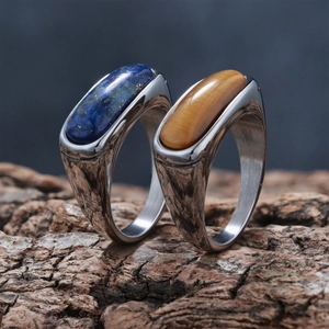 Close-up of vintage silver rings with tiger eye and blue stone on wood bark texture