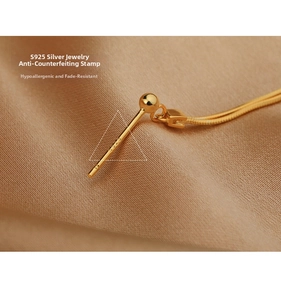 Macro shot of S925 sterling silver hallmark on polished gold tassel earrings detail