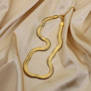 Dettaglio collana a serpente piatta dorata con chiusura a moschettone su seta