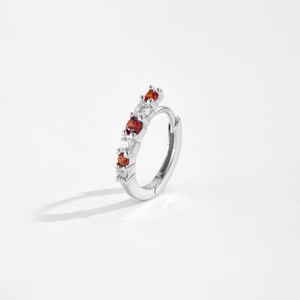 Macro detail of S925 silver hoop earrings with inlaid red and clear cubic zirconia stones