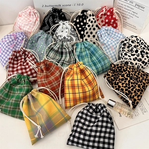 Flat lay of colorful drawstring fabric pouches with various patterns for small jewelry