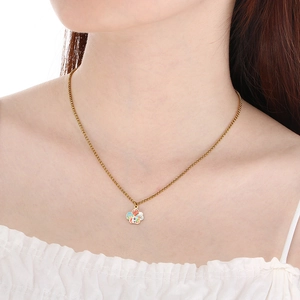 Close-up of golden necklace with colorful enamel floral pendant on a female model