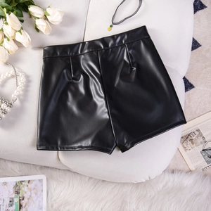Flachbild von schwarzen PU-Leder-Shorts mit hoher Taille und Mode-Accessoires auf Teppich