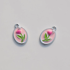 Detail of tulip oval pendants with pink enamel heart flower and small pearl accents