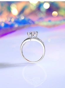 Macro shot of silver crown ring featuring multi-prong set moissanite and side accents
