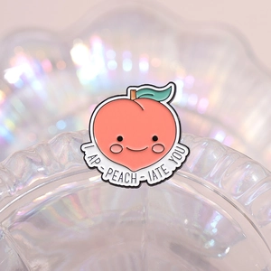 Cute cartoon peach enamel pin with I AP-PEACH-IATE YOU banner on iridescent glass