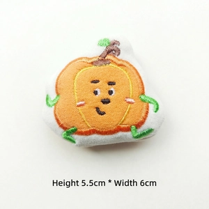 Detailed view of plush embroidered orange pumpkin doll with cute expression, 5.5x6cm size