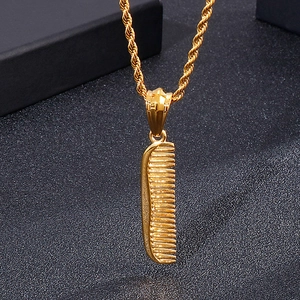 Macro shot of gold comb pendant necklace with twisted rope chain on black background