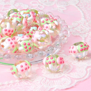 Close-up of DIY acrylic beads with cute pink and green mushroom patterns in a glass dish