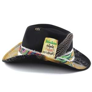Detail of ethnic ribbon, real feather and embroidery on black wide-brim cowboy hat