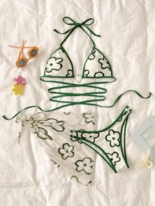 Détail à plat d'un bikini floral trois pièces avec boucle coeur et jupe paréo assortie