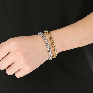 Close-up of gold and silver twisted rope chains worn on wrist with sleek metal finish
