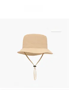 Dettaglio del cappello kaki con cordino antivento regolabile e chiusura a strozzo nera