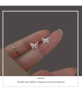 Macro shot of silver butterfly stud earrings featuring colorful marquise-shaped zircons
