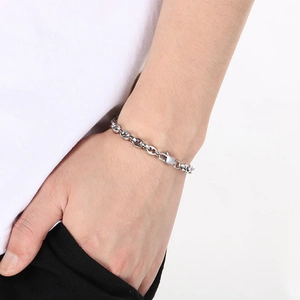 Polished stainless steel pig nose chain link bracelet worn on wrist with lobster clasp