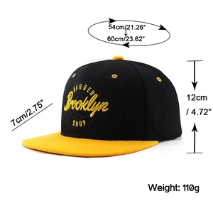 Détail de la broderie Brooklyn sur la casquette de baseball noire et jaune à bord plat