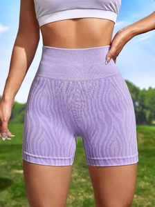 Detail of high-waist purple sports shorts with textured knit fabric on outdoor background